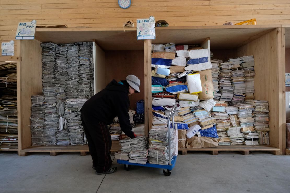 A worker sorts newspapers and magazines for recycling at a waste center in Kamikatsu.
