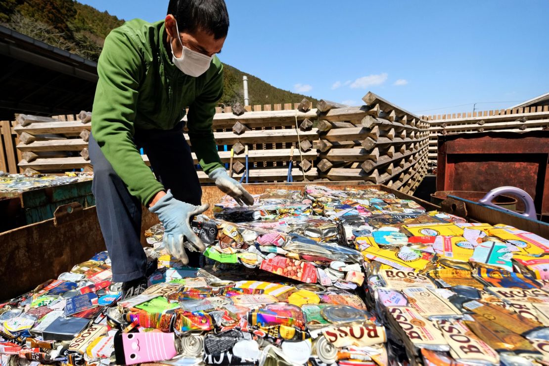 A resident stacks sheets of compacted aluminum cans at a waste center in Kamikatsu, Tokushima prefecture.