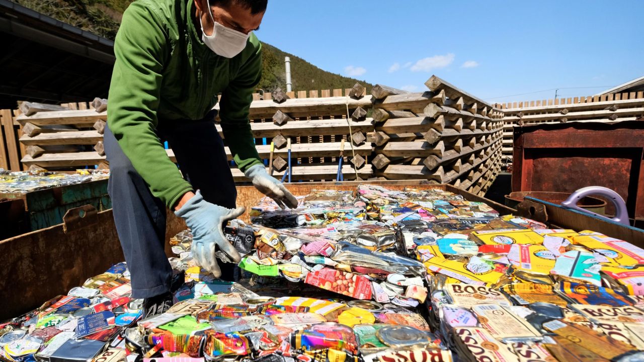 A resident stacks sheets of compacted aluminum cans at a waste center in Kamikatsu, Tokushima prefecture.