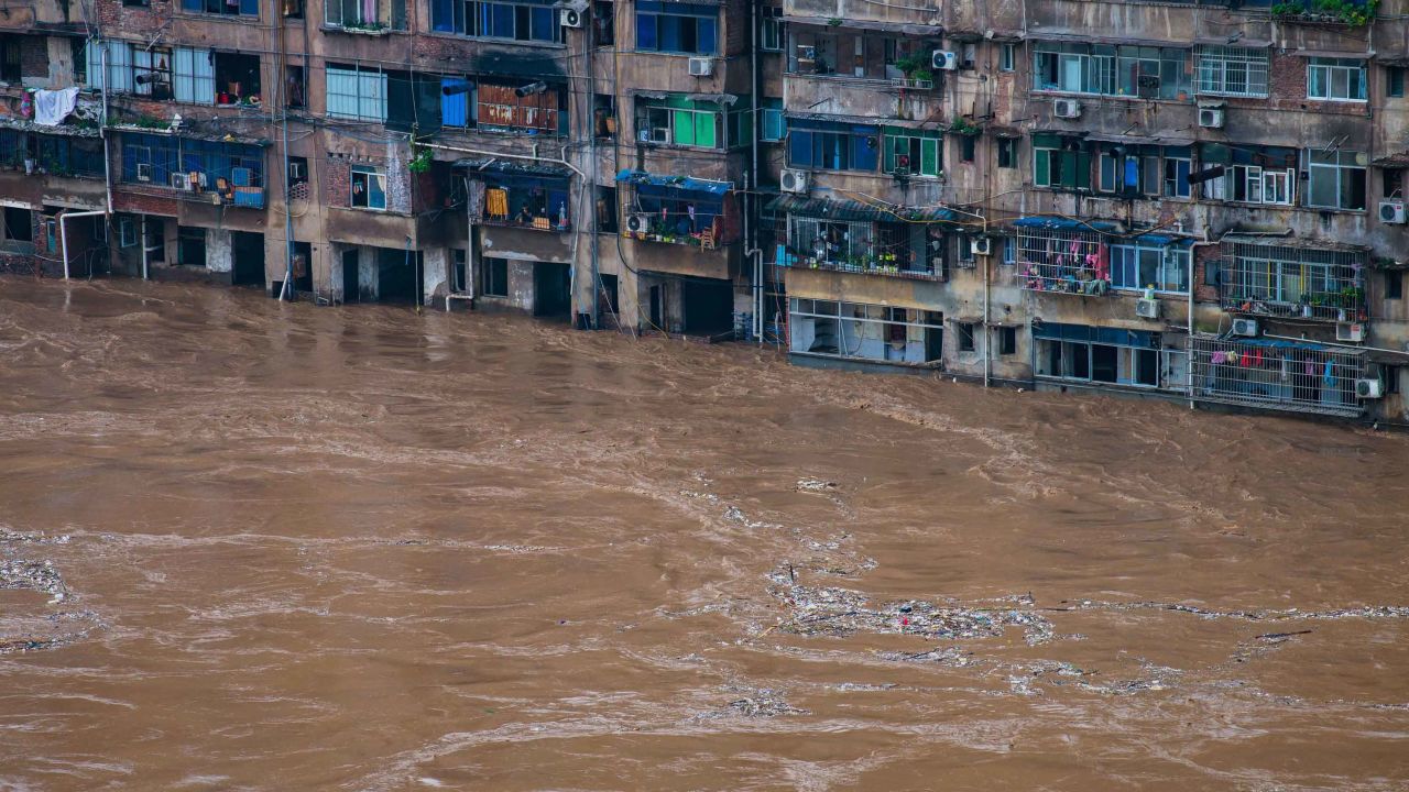 Floodwaters flow past a residential building in Chongqing in southwest China on July 1.