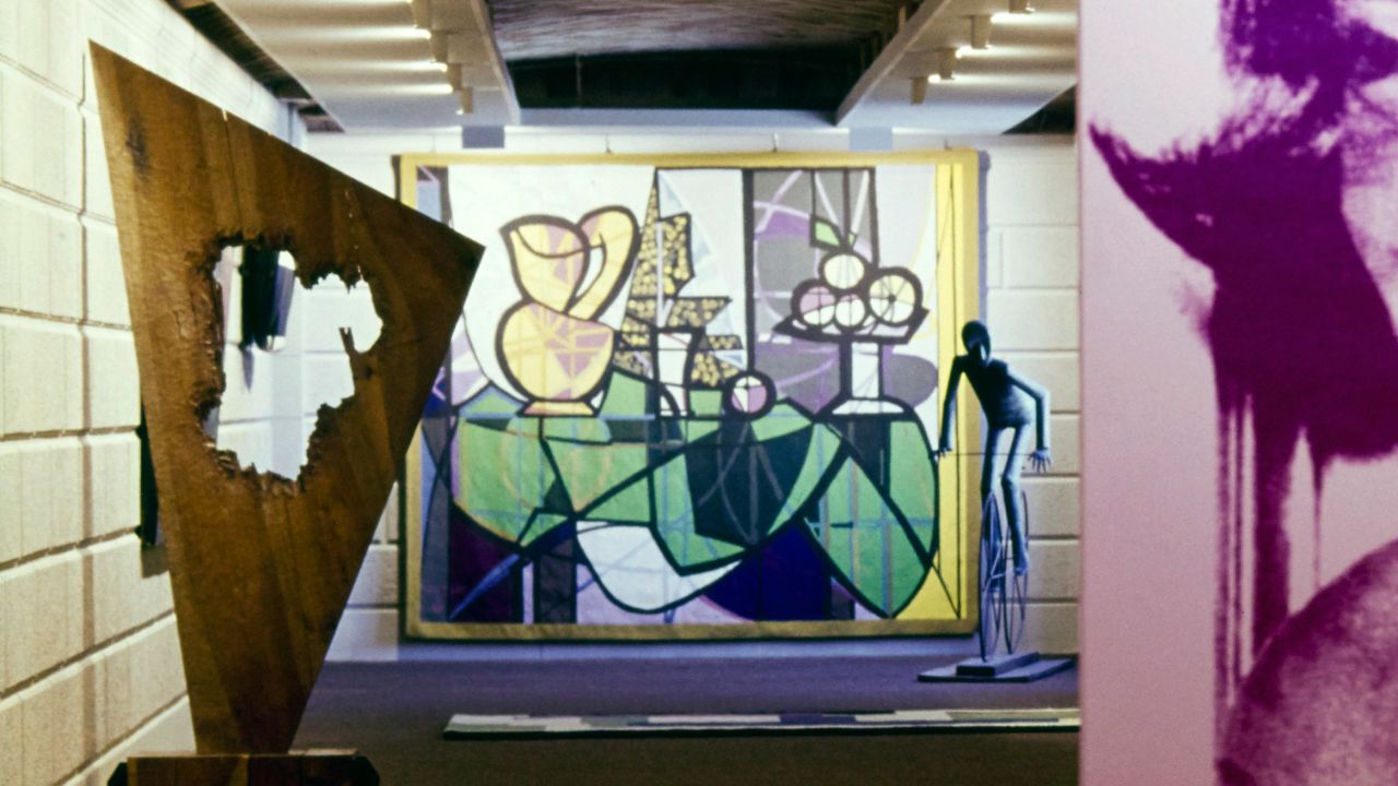 Vogue, June 01, 1975: In the underground art gallery in the home of Happy Rockefeller in New York state, the far wall is covered by a 1970 tapestry version of the 1931 Picasso painting "Pitcher and Bowl of Fruit."