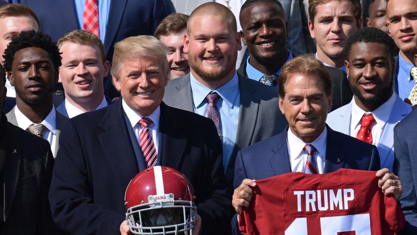 President Donald Trump, center, poses for a photo with the 2017 NCAA National Champion University of Alabama football team at the White House in Washington, Tuesday, April 10, 2018. Alabama head coach Nick Saban holds the Trump jersey at right.
