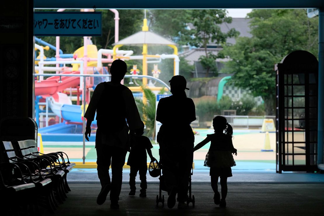 Parents and children enter a swimming pool open to a limited number of visitors as a preventive measure against coronavirus at Tokyo's Toshimaen amusement park on July 13.