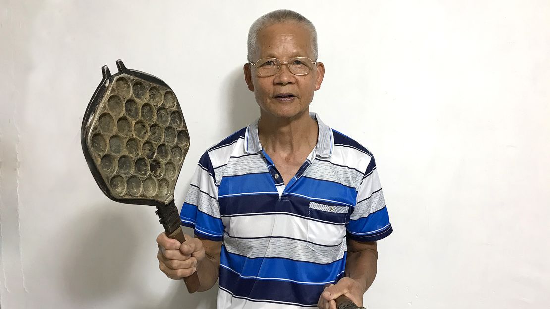 Lee Sui Yuen, a retired egg waffle hawker, holds one of his decades-old waffle irons. 