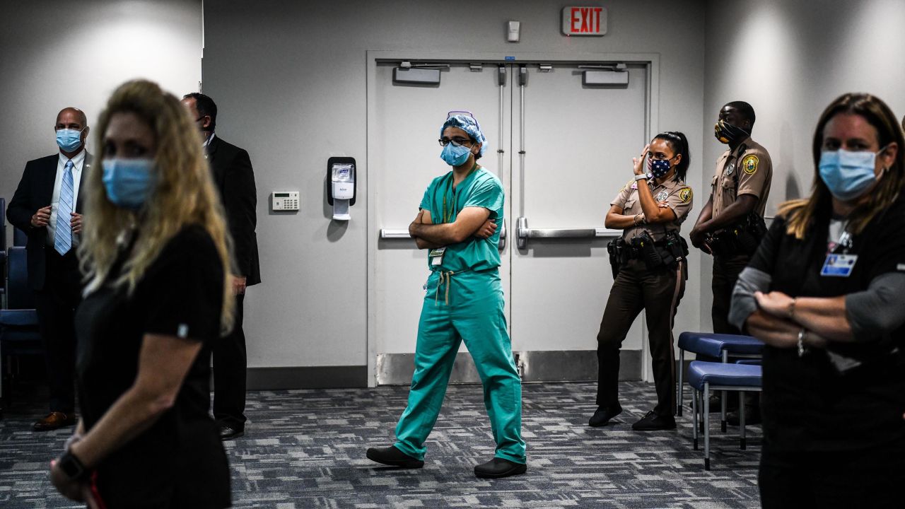 Dr. David de la Zerda (C) listens to the governor of Florida during a press conference to address the rise of coronavirus cases in the state, at Jackson Memorial Hospital in Miami, on July 13, 2020. - Virus epicenter Florida saw 12,624 new cases on July 12 -- the second highest daily count recorded by any state, after its own record of 15,300 new COVID-19 cases a day earlier. (Photo by CHANDAN KHANNA / AFP) (Photo by CHANDAN KHANNA/AFP via Getty Images)