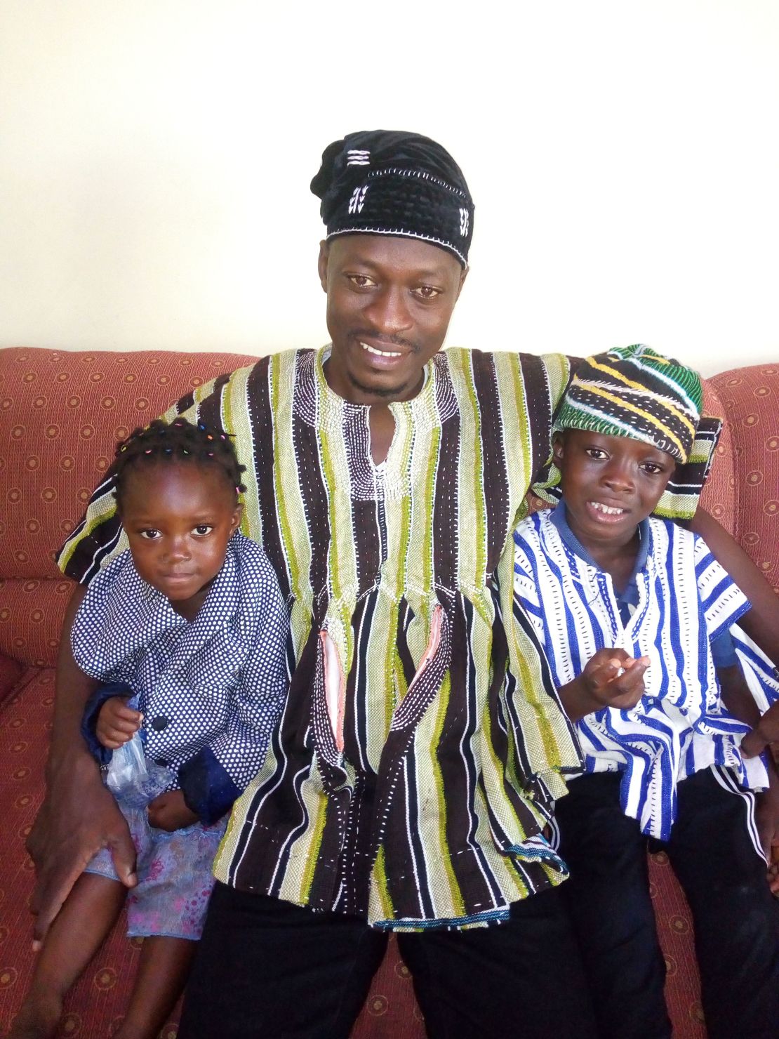 Abdul Razak Issah (center) of Tamale, Ghana, and his family sit on the couch at home and get ready to connect with Brittany McMillan's family in Coldstream, British Columbia, Canada, through Empatico. His son Zul-Kifl (right), age 6, has bonded with Jonah McMillan, age 7. 