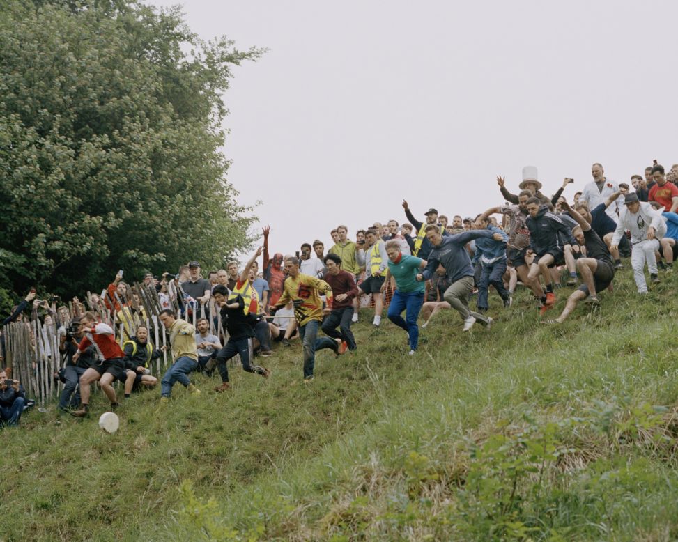 Every year, a village in Gloucestershire hosts an annual cheese-rolling competition, in which participants chase a wheel of cheese down a steep hill. Scroll through to see more of Orlando Gili's images of the English at play.