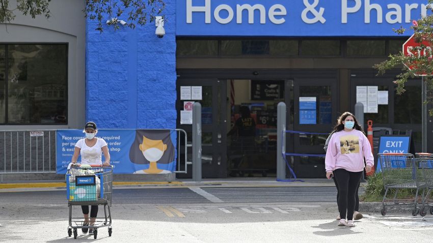 Customers wear masks as they leave a Walmart Supercenter, Sunday, June 28, 2020, in Ocoee, Fla. A mandatory mask-wearing order is in place during the new coronavirus pandemic. (Phelan M. Ebenhack via AP)