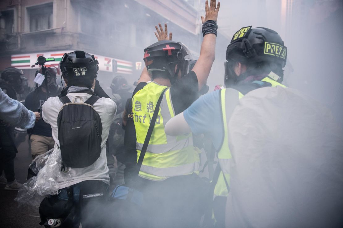 A journalist raises his hands after police fire tear gas on October 1, 2019 in Hong Kong. Pressure has been growing on reporters in the city under a new security law. 