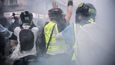 A journalist raises his hands after police fire tear gas on October 1, 2019 in Hong Kong. Pressure has been growing on reporters in the city under a new security law. 