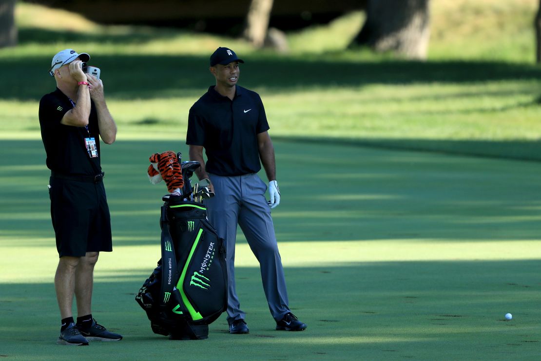 Woods looks over a shot with his caddy during practice ahead of The Memorial Tournament.