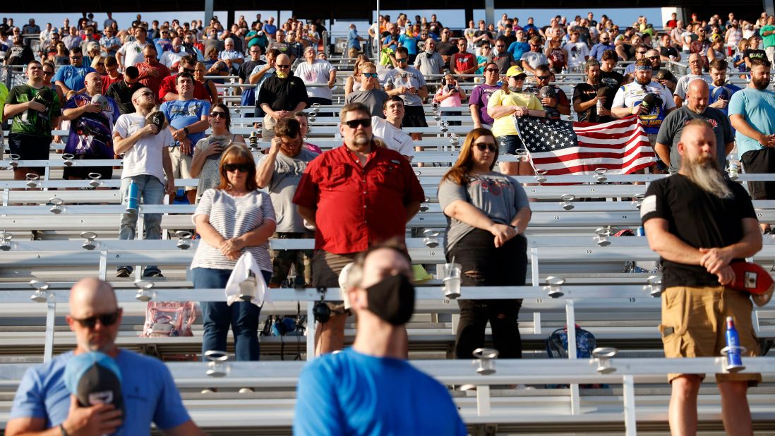Fans stand during the national anthem prior to the race.