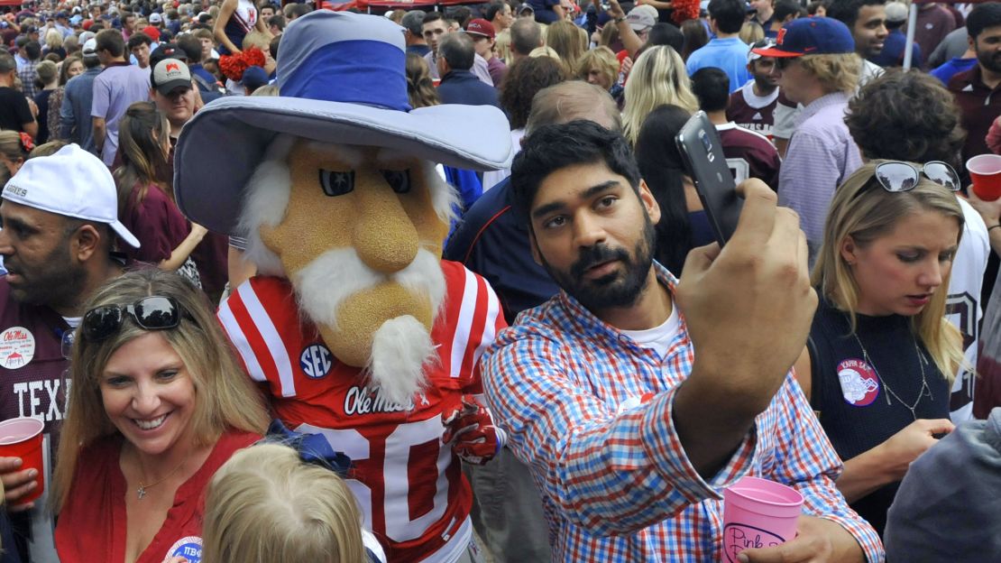 A Mississippi fan takes a picture with some dressed up a former mascot, Colonel Reb, in 2015.