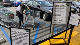 A Whole Food employee sanitizes shopping charts amid coronavirus concerns before they are used by waiting patrons outside the 365 Whole Foods Market in the Los Feliz neighborhood of Los Angeles, Tuesday, March 31, 2020. (AP Photo/Damian Dovarganes)