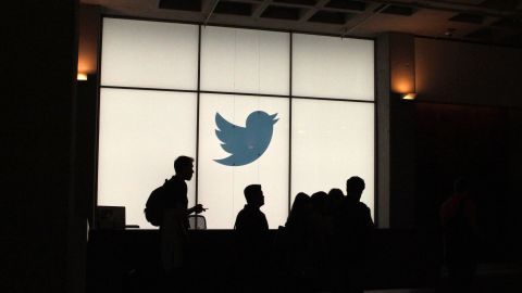 Twitter employees walk by the company's headquarters in San Francisco.