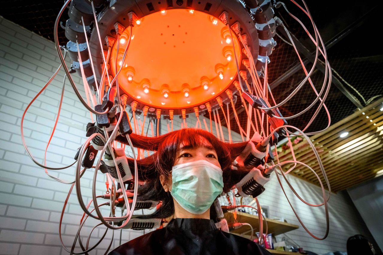 A woman has her hair curled by special equipment at a beauty salon in Bangkok, Thailand, on Sunday, July 12.