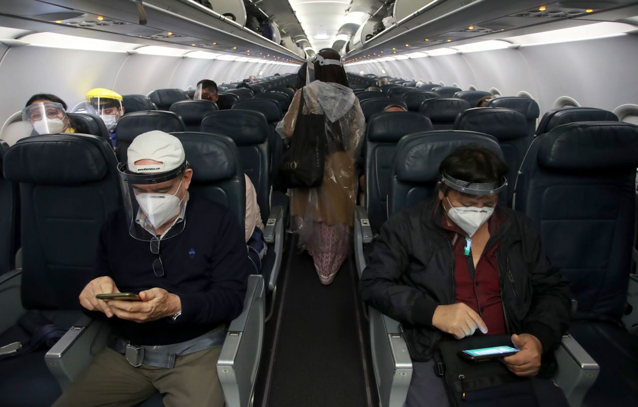 Passengers check their cell phones before their flight took off from Lima, Peru, on Wednesday, July 15. Domestic air travel resumed in Peru after being suspended for four months.
