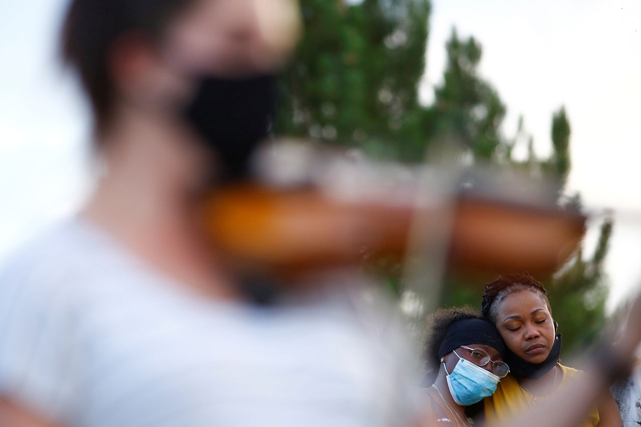 Sheneen McClain, center, weeps while a violinist plays at a candlelight vigil for her son, Elijah, in Aurora, Colorado, on Saturday, July 11. <a href="https://www.cnn.com/2020/07/03/us/officers-in-photos-near-elijah-mcclain-memorial-fired/index.html" target="_blank">Elijah McClain's death last year</a> is one of several that has attracted renewed attention following the deaths of other Black people at the hands of police, like George Floyd in Minneapolis and Rayshard Brooks in Atlanta.