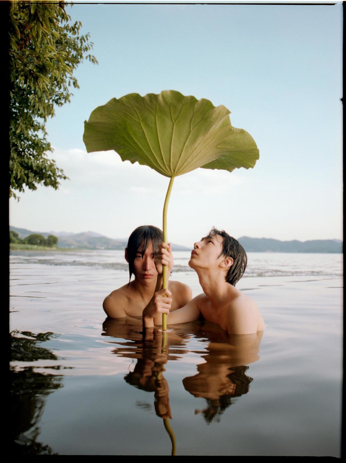 Models pose with giant lotus leaves found on location.