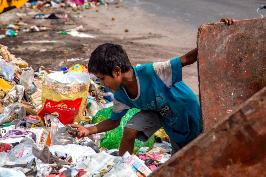  An Indian child ragpicker collects valuable waste items from a dumping site on July 15, 2020  in New Delhi, India.  