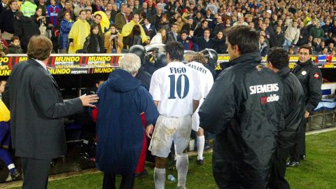 Figo leaves the pitch as play was suspended during Barcelona's match against Real.