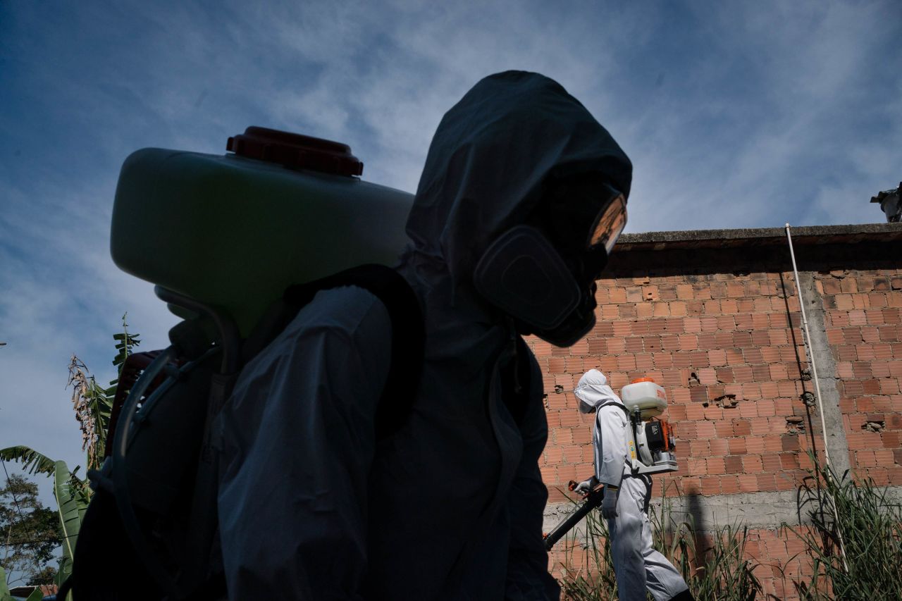Volunteers spray disinfectant in a Rio de Janeiro alleyway to help contain the spread of the coronavirus on Sunday, July 12.