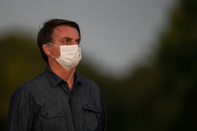 Brazilian President Jair Bolsonaro is seen wearing a face mask in front of his official residence in Brasilia on Wednesday, July 15. Bolsonaro tested positive for Covid-19 again, a week after an initial test indicated he had been infected with the virus.