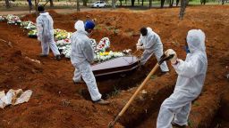 SAO PAULO, BRAZIL - JULY 16: Cemetery workers in protective suits bury Elisa Moreira de Araujo, 79, a victim of coronavirus (COVID-19) at the Vila Formosa cemetery on July 16, 2020 in Sao Paulo, Brazil. Brazil is reaching two million confirmed cases of coronavirus (COVID-19). The country is second only to the United States in number of cases and deaths. According to the Brazilian Health Ministry, Brazil has over 75.000 deaths. (Photo by Alexandre Schneider/Getty Images)