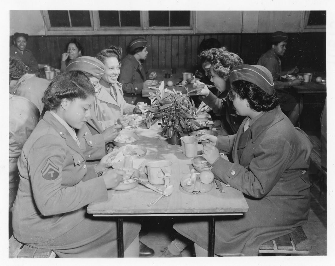 The women of the 6888th eat at a mess table in England. 