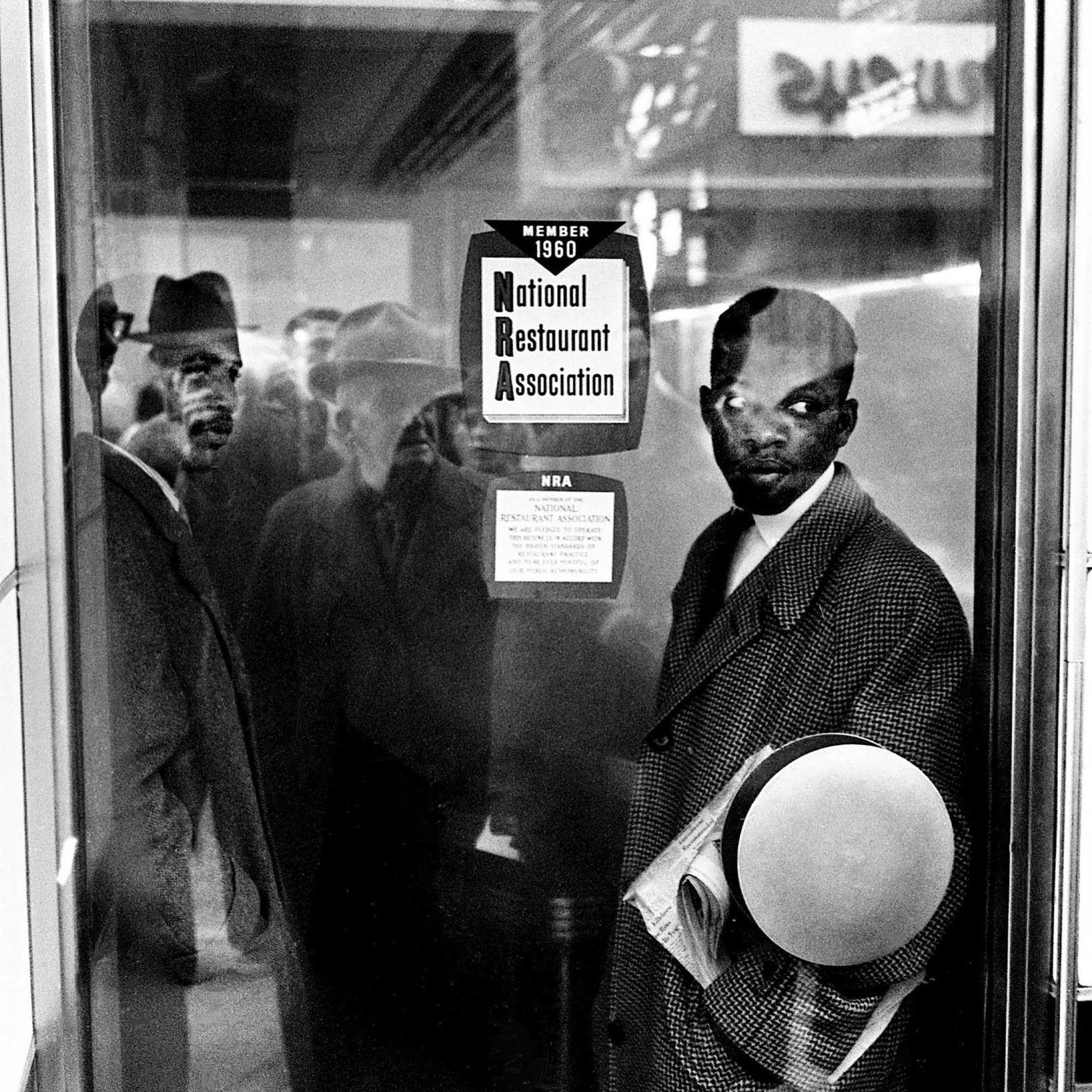 Lewis, right, and fellow student demonstrator James Bevel stand inside the door of a Nashville, Tennessee, restaurant during a sit-in protest in 1960. The manager turned on a fumigating machine to disrupt the sit-in.