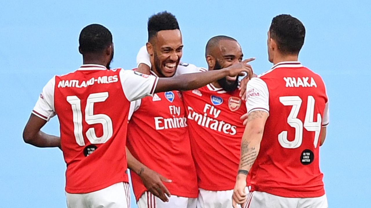 Arsenal's Gabonese striker Pierre-Emerick Aubameyang (second left) is surrounded by teammates after scoring the opening goal of the FA Cup semifinal against Manchester City at Wembley. 
