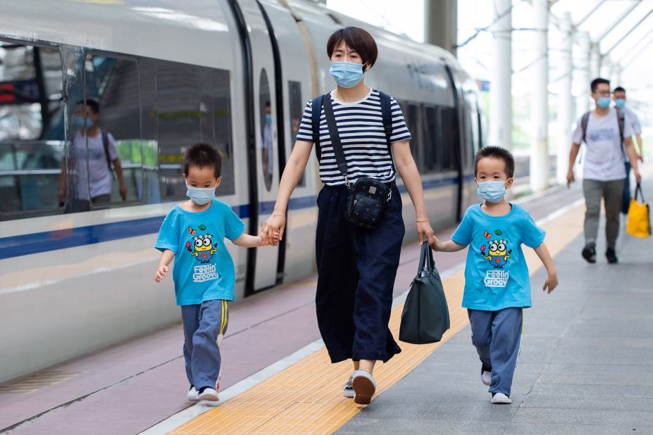 <strong>China: </strong>Children wearing face masks prepare to board a train at Nanjing Railway Station before the three-day Dragon Boat Festival holiday on June 24, 2020.