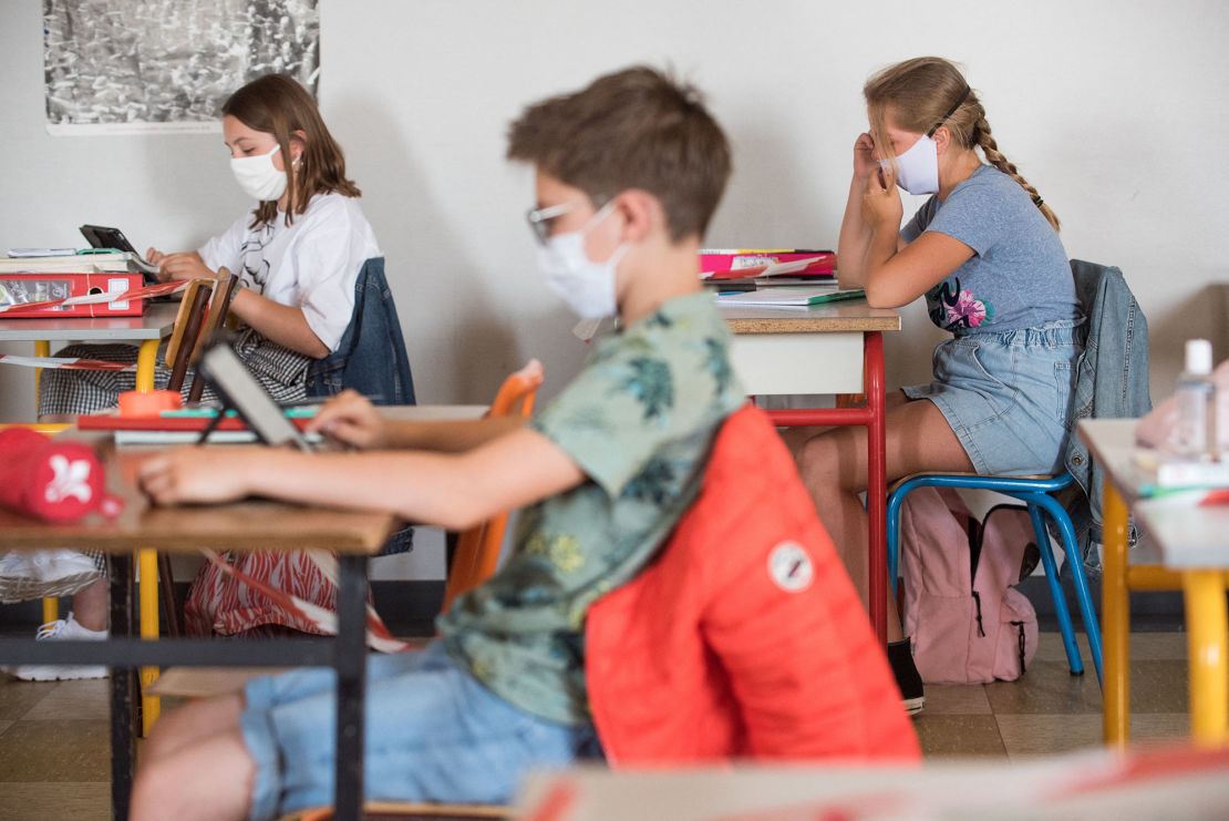 Pupils wearing fabric masks listen to their teacher in a school in Beaucamps-Ligny, near Lille, France. Masks are now compulsory in all enclosed spaces there.