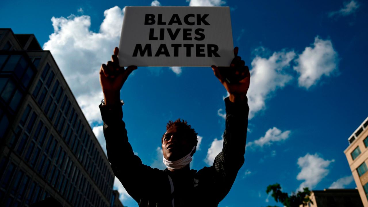 A protester holds up a sign near Black Lives Matter plaza near the White House in Washington, DC on June 24, 2020. (Photo by ANDREW CABALLERO-REYNOLDS / AFP) (Photo by ANDREW CABALLERO-REYNOLDS/AFP via Getty Images)