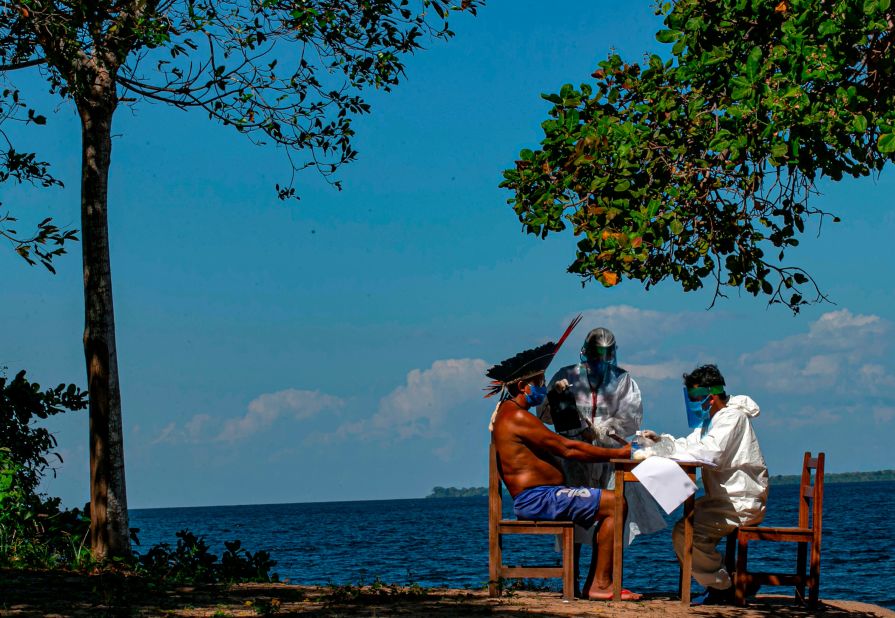 Indigenous nurses in Santarem, Brazil, administer a Covid-19 test on Chief Domingos from the Arapium tribe on July 19.