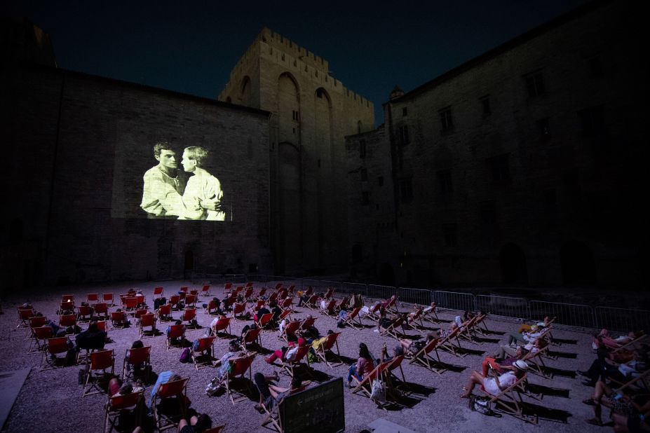 People watch a video projection in Avignon, France, on July 18. Since the Avignon Theatre Festival has been canceled because of the coronavirus pandemic, the festival's organization has been projecting plays that made its history.