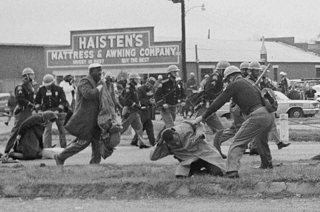 A state trooper swings a billy club at John Lewis, right foreground, in 1965 on "Bloody Sunday" in Selma, Alabama.