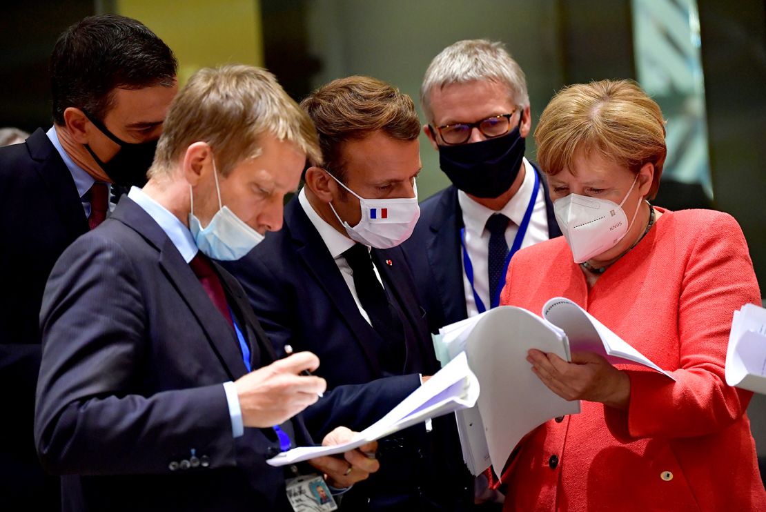 Spain's Prime Minister Pedro Sanchez (left), French President Emmanuel Macron (center) and German Chancellor Angela Merkel (right) looking at documents during the EU summit in Brussels on Monday.