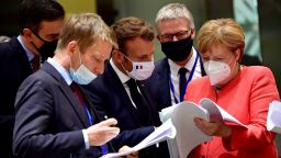 Spain's Prime Minister Pedro Sanchez (L), French President Emmanuel Macron (C) and German Chancellor Angela Merkel (R) look into documents during an EU summit in Brussels on July 20, 2020, as the leaders of the European Union hold their first face-to-face summit over a post-virus economic rescue plan. (Photo by JOHN THYS / POOL / AFP) (Photo by JOHN THYS/POOL/AFP via Getty Images)