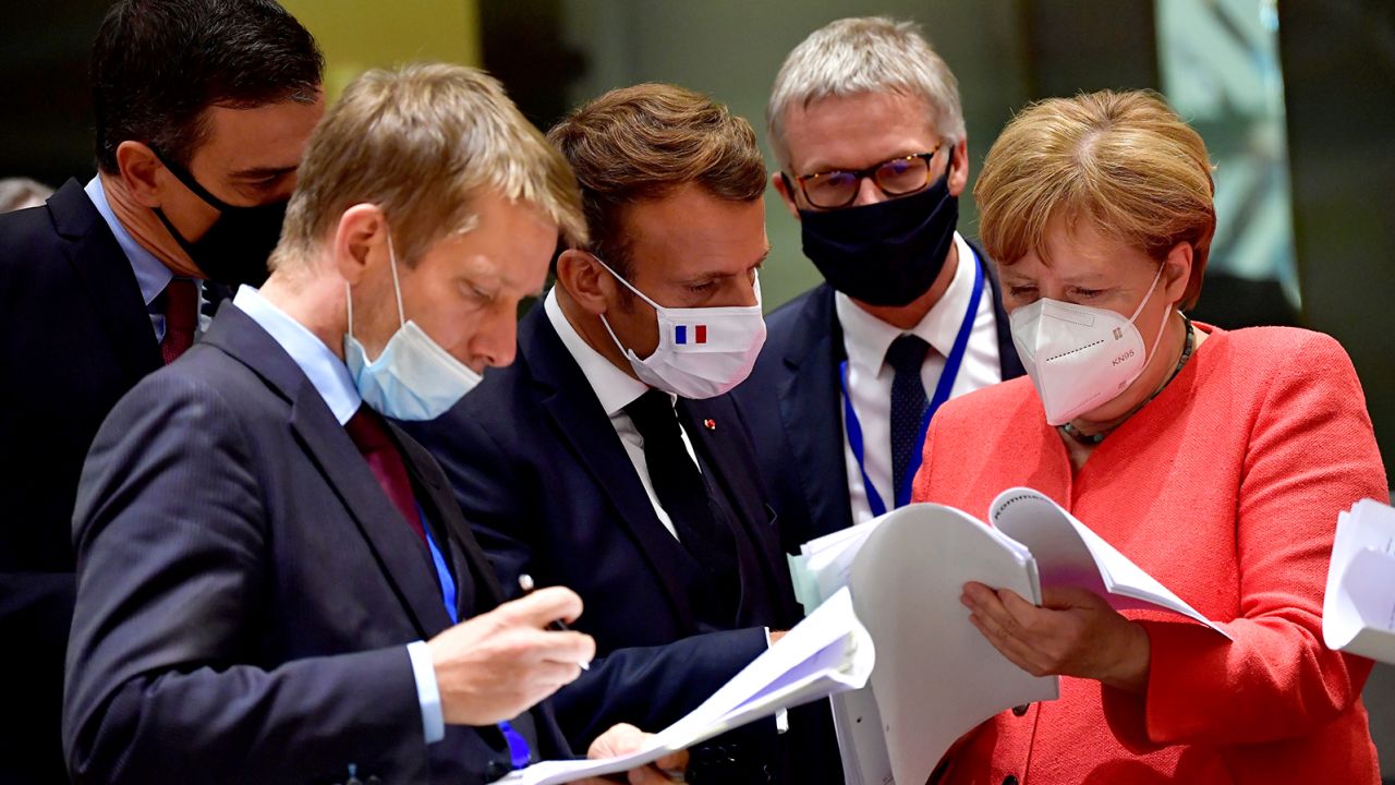Spain's Prime Minister Pedro Sanchez (left), French President Emmanuel Macron (center) and German Chancellor Angela Merkel (right) looking at documents during the EU summit in Brussels on Monday.