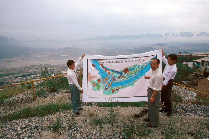 Workers hold up a layout plan of the Three Gorges Dam project by the Yangtze river in Hubei province in September 1995. Scroll through the gallery for images of the Three Gorges Dam, through the years.