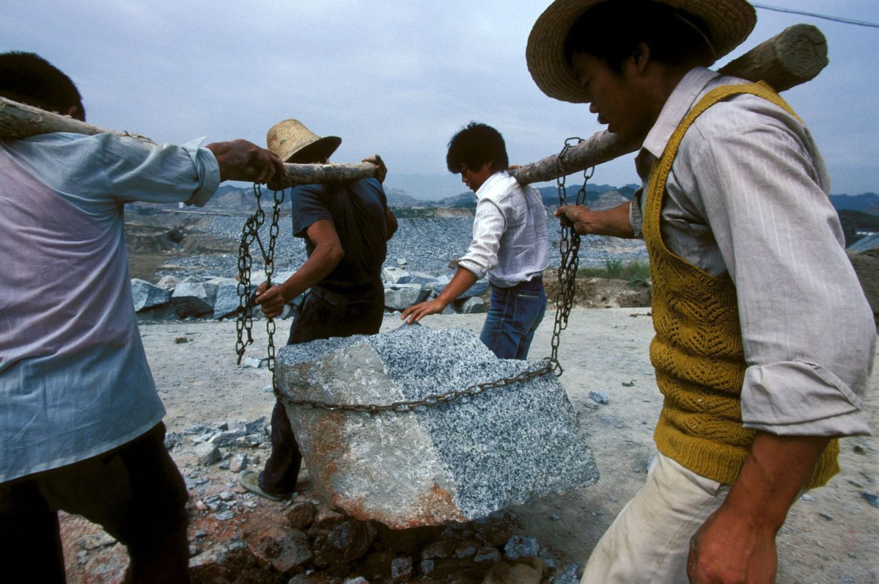 Workers carry a large piece of stone at the building site of the Three Gorges Dam in September 1995.<br />