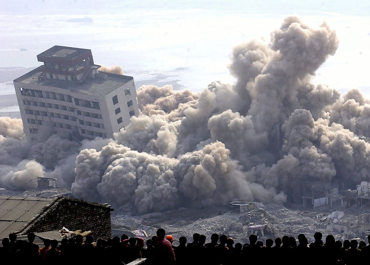 Residents of Fengjie, in southwest China's Chongqing, watch the demolition of buildings in their town on November 4, 2002, to make room for the Three Gorges Dam's resevoir. 