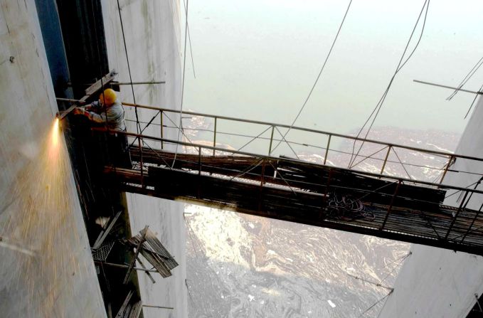 A worker welds on a flood relief channel of the Three Gorges Dam in June 1, 2003.