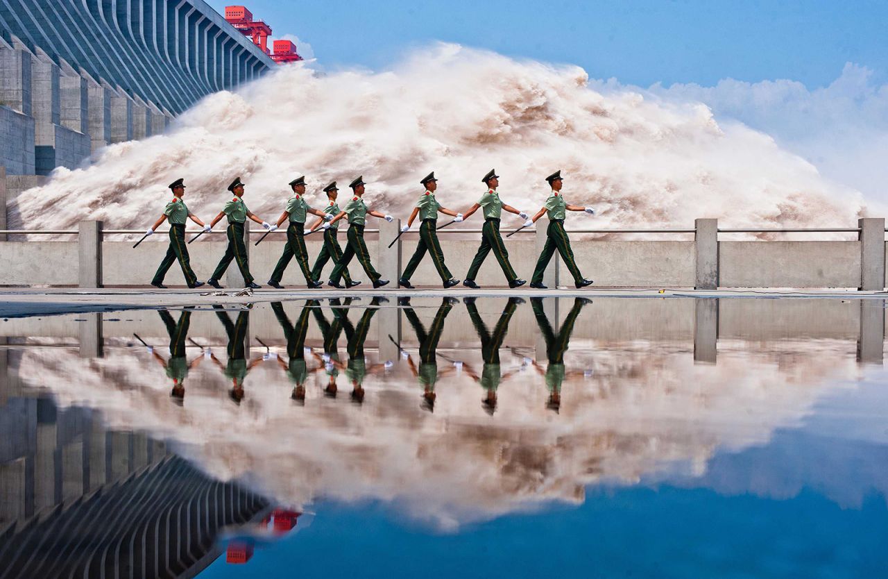 Armed police patrol march by the Three Gorges Dam as flood water is released from its spillways on July 25, 2012.