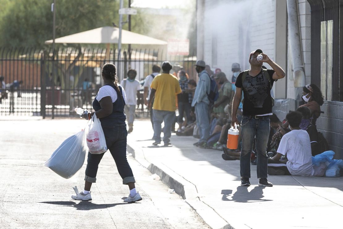 People experiencing homelessness and housing insecurity receive water, food and heat relief at Andre House in Phoenix on July 11, 2020. The pandemic is forcing cities to change how they keep residents safe from extreme heat.