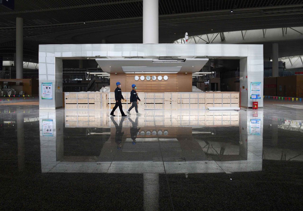 Staff members walk through the departure hall of the terminal building of Jiaodong International Airport. 