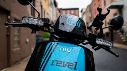 A Revel brand moped sits parked on a residential street, June 18, 2019 in the Brooklyn borough of New York City. The ride-share moped company has deployed over 1,000 electric mopeds through Brooklyn and Queens. The fully electric mopeds top out at 30 miles per hour and are available to rent by the minute via smartphone.