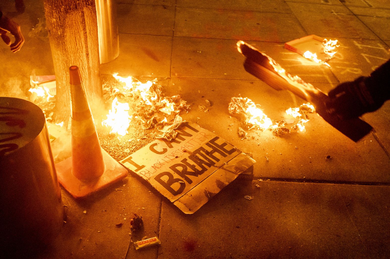 A Black Lives Matter protester burns a sign outside the courthouse early on July 21.