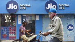 People on bicycles pass by a Jio store in Kolkata, India, on July 13, 2020. (Photo by Indranil Aditya/NurPhoto via AP)